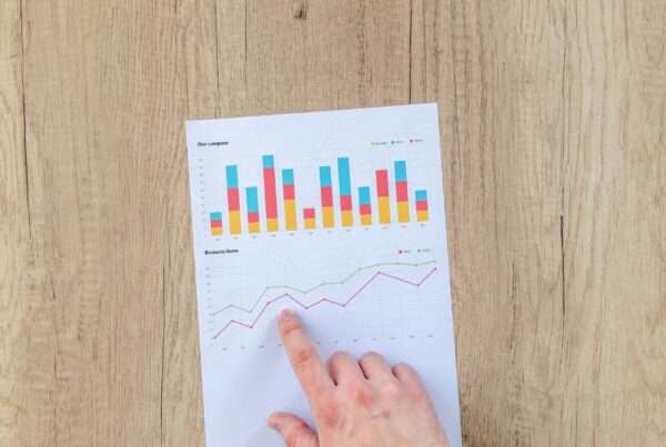 Business professional analyzing data strategy charts and graphs on a wooden desk