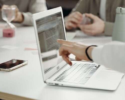 Business professional using laptop with AI-powered productivity tools in modern office