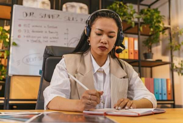 Professional business agent wearing a headset and recording a sales call in an office environment