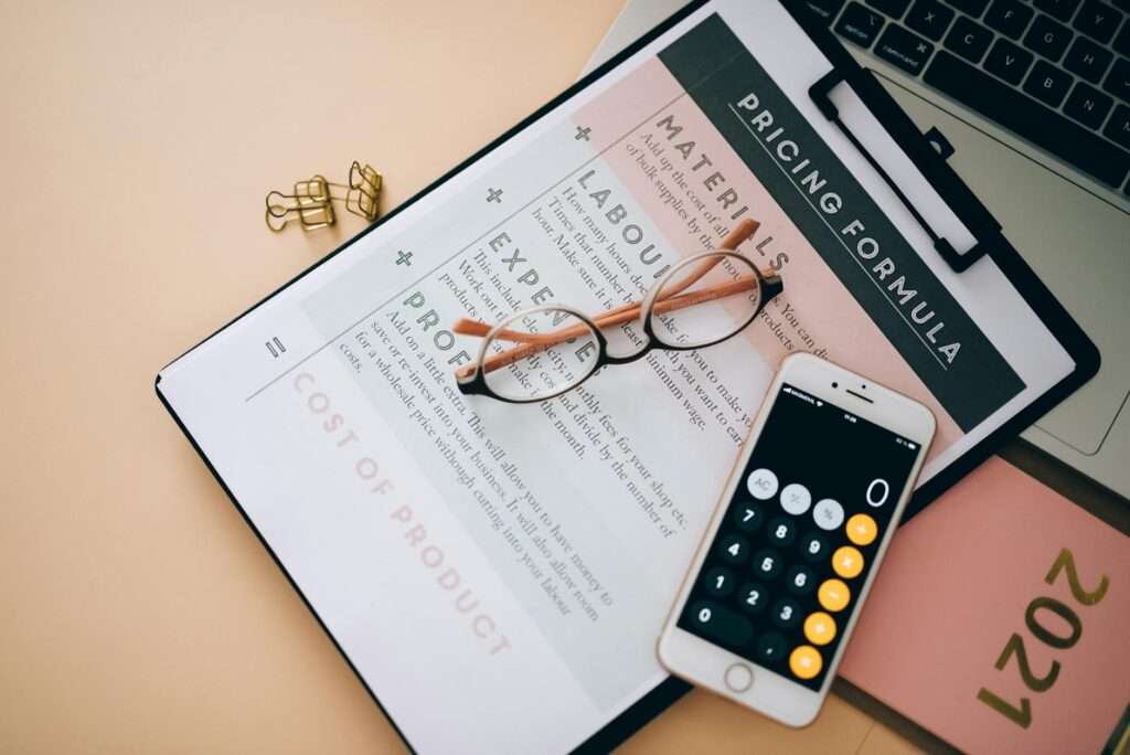 AI Phone Agent Pricing Models: What Businesses Actually Pay in 2026 2 Business pricing analysis documents and phone on a desk representing AI phone agent pricing models