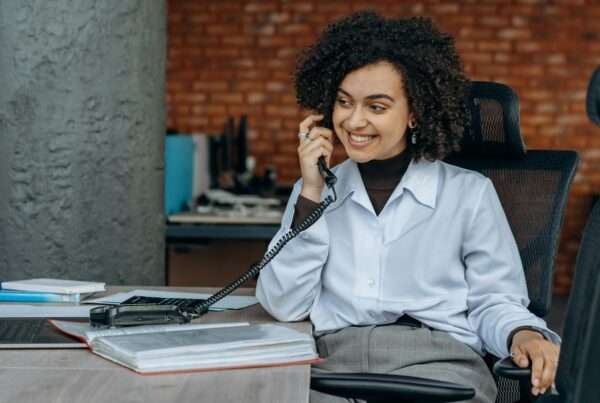 Business woman smiling while taking a customer call in a professional office setting
