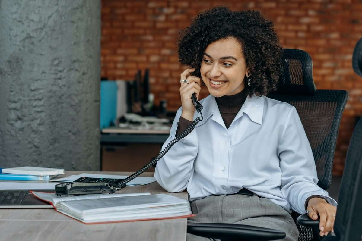 Business woman smiling while taking a customer call in a professional office setting
