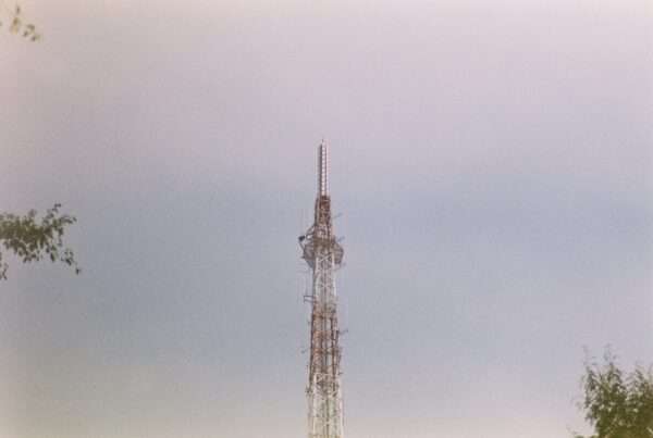 Connecting the Airwaves: How Cytranet Delivers Mission-Critical Internet, Fiber, and Private Data Transport Services to the Broadcast Industry 8 Tall broadcast radio tower against a cloudy sky representing mission-critical internet and fiber connectivity for the broadcast industry