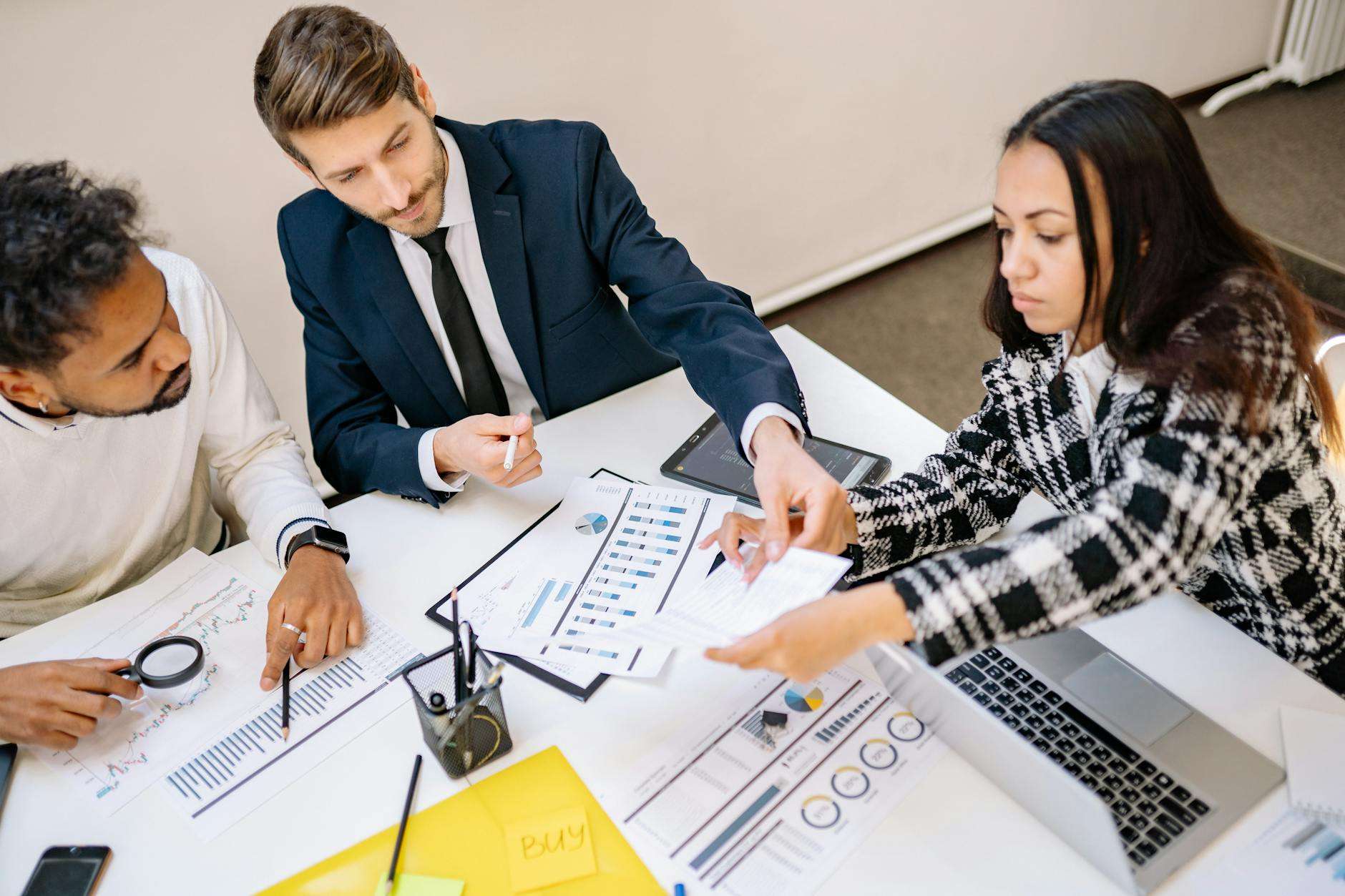 Business professionals engaged in a collaborative meeting with charts and strategic planning documents