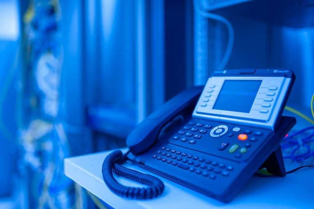 Modern office phone in blue lighting representing business phone system features and VoIP communication solutions
