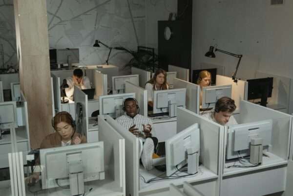 Call center agents working at computers in a modern contact center environment representing call monitoring software