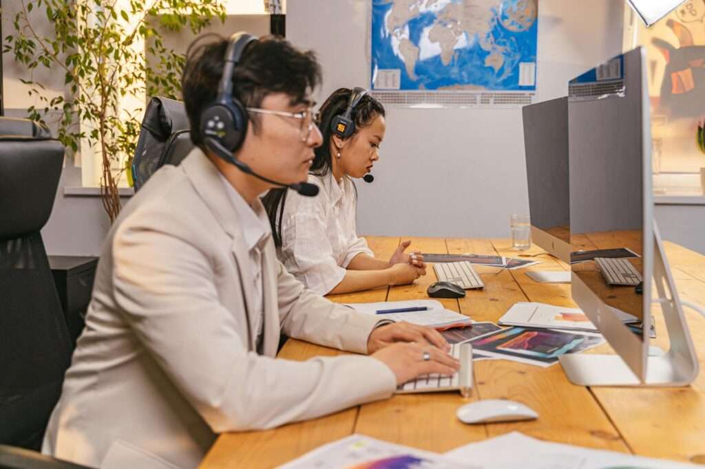 Professional call center team working with headsets in a modern office
