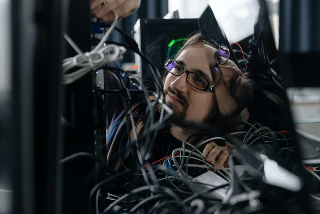 IT support technician organizing network cables at a professional workstation