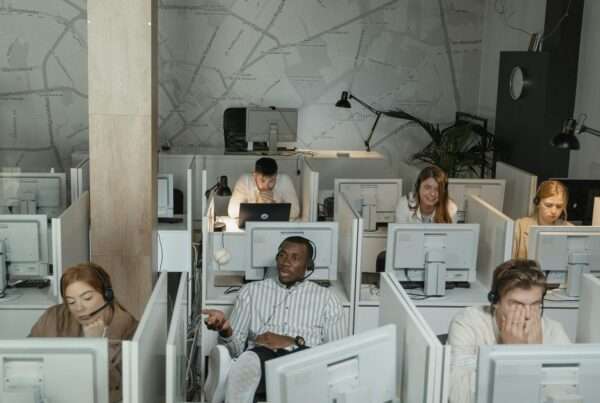 Diverse group of customer service agents with headsets working in a modern contact center