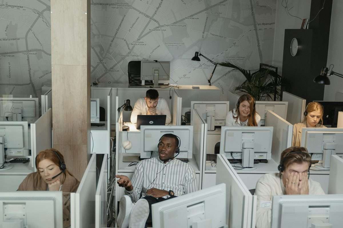 Diverse group of customer service agents with headsets working in a modern contact center
