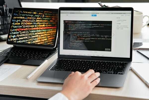 Developer writing code on laptop representing custom software development and business technology solutions