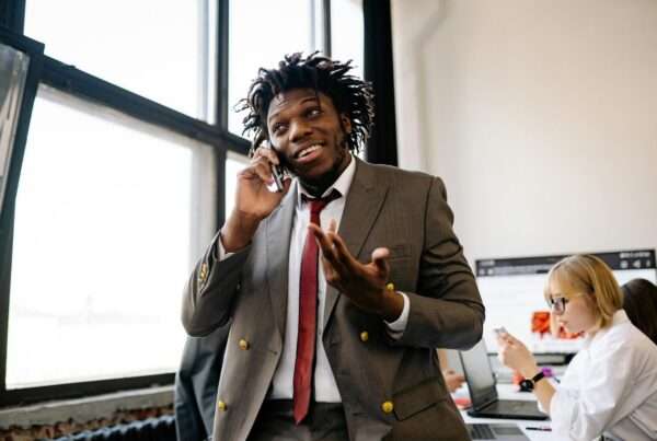 Professional businessman smiling while talking on the phone in an office setting
