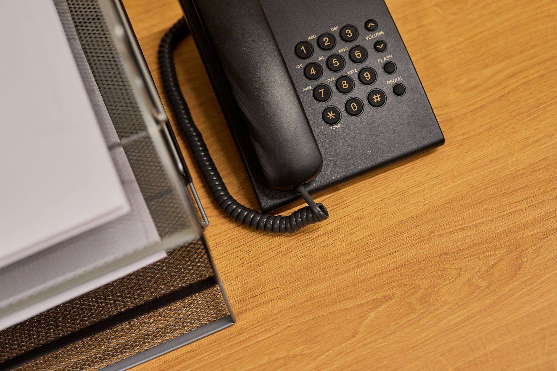 Black office telephone on a tidy business desk