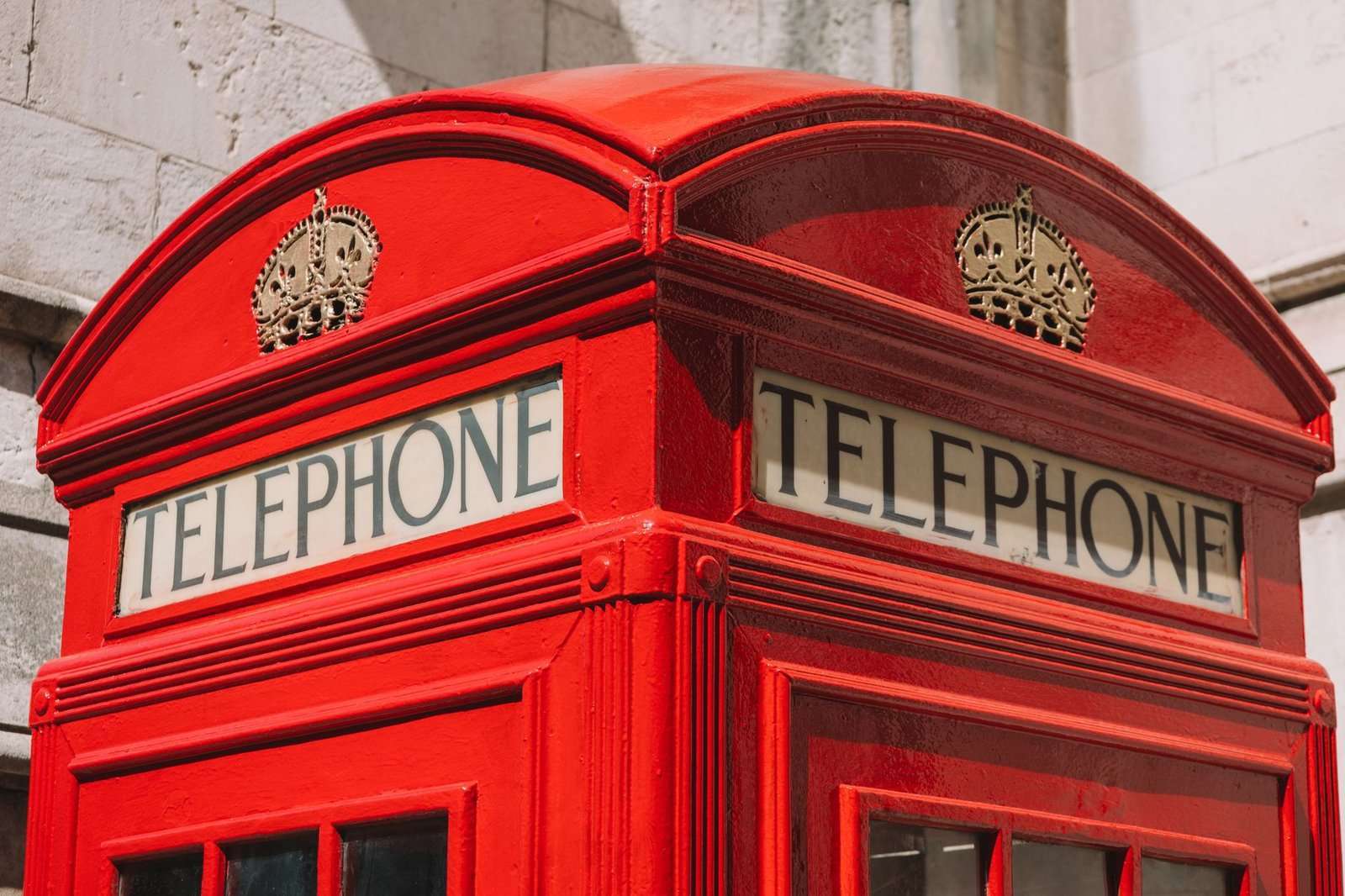 How to Call the UK From the US: Country Code, Area Codes & Rates 4 Classic British red telephone box on a city street in the United Kingdom