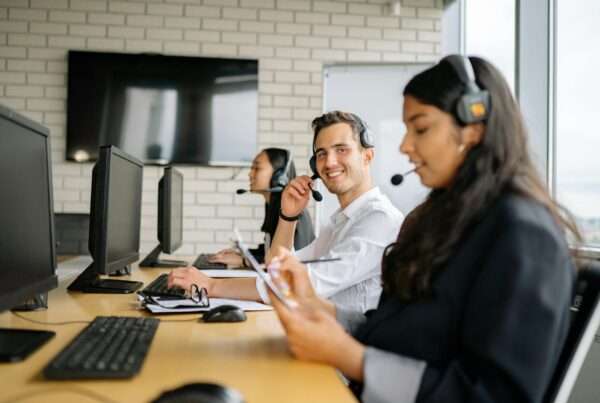 Smiling contact center agents wearing headsets working together