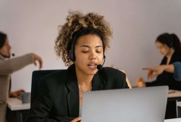 Customer support agent wearing a headset and working on a laptop