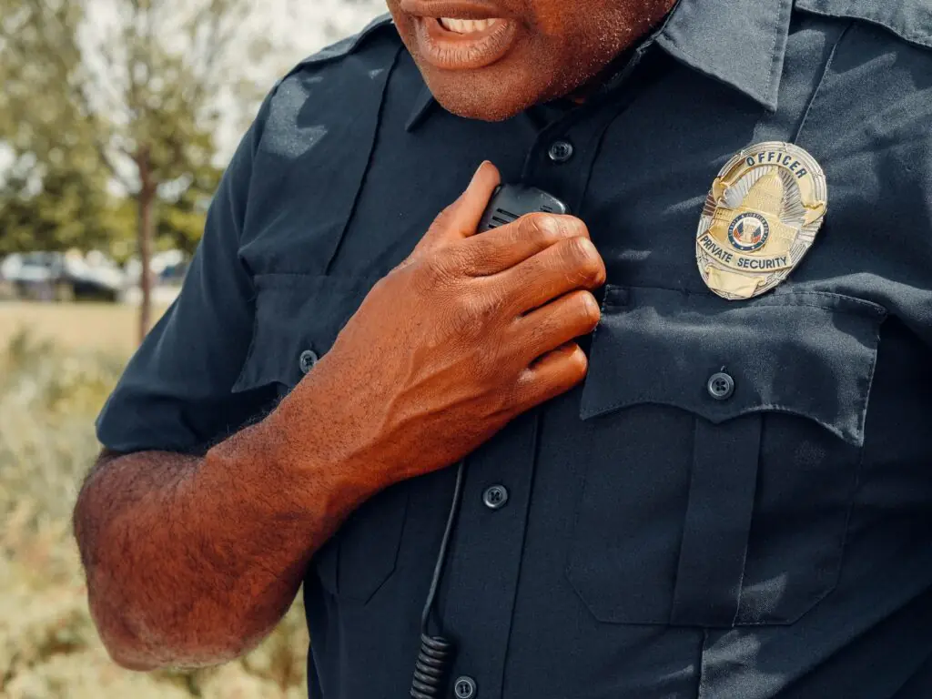 Uniformed security officer communicating on an encrypted two-way radio, representing Cytranet communication and electronics solutions for security guard companies