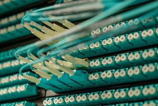 Fiber optic cables connected to a server rack representing high-capacity business network infrastructure