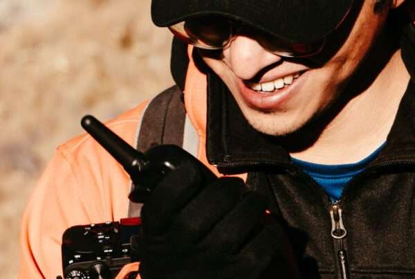 Field worker using a Motorola TLK push-to-talk two-way radio outdoors, supplied and supported by Cytranet in Las Vegas
