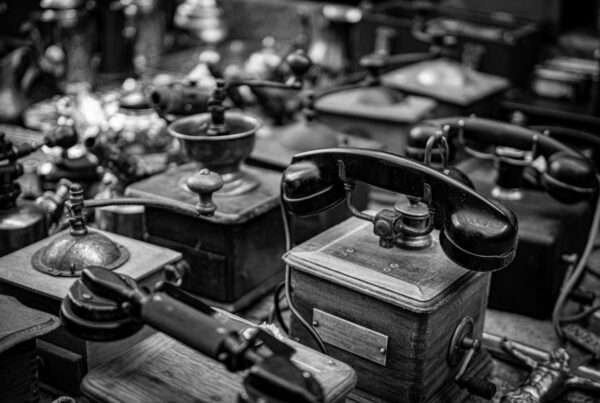 From Bell to VoIP: The Complete History of the Telephone 5 Collection of antique telephones in black and white showcasing the history and evolution of telephone communication technology