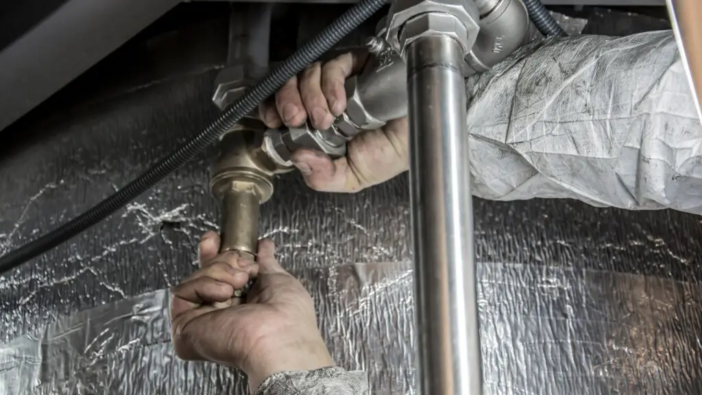 Technician installing steel pipework on a job site, representing AI answering services that book appointments and triage emergencies for plumbing, HVAC, and electrical businesses