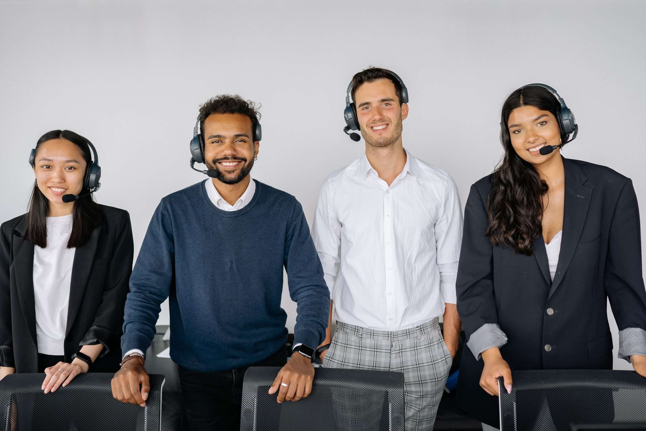 What Is the ROI of an AI Receptionist? A Sector-by-Sector Guide 6 Team of customer service representatives wearing headsets answering calls in a modern office, representing AI receptionist call handling