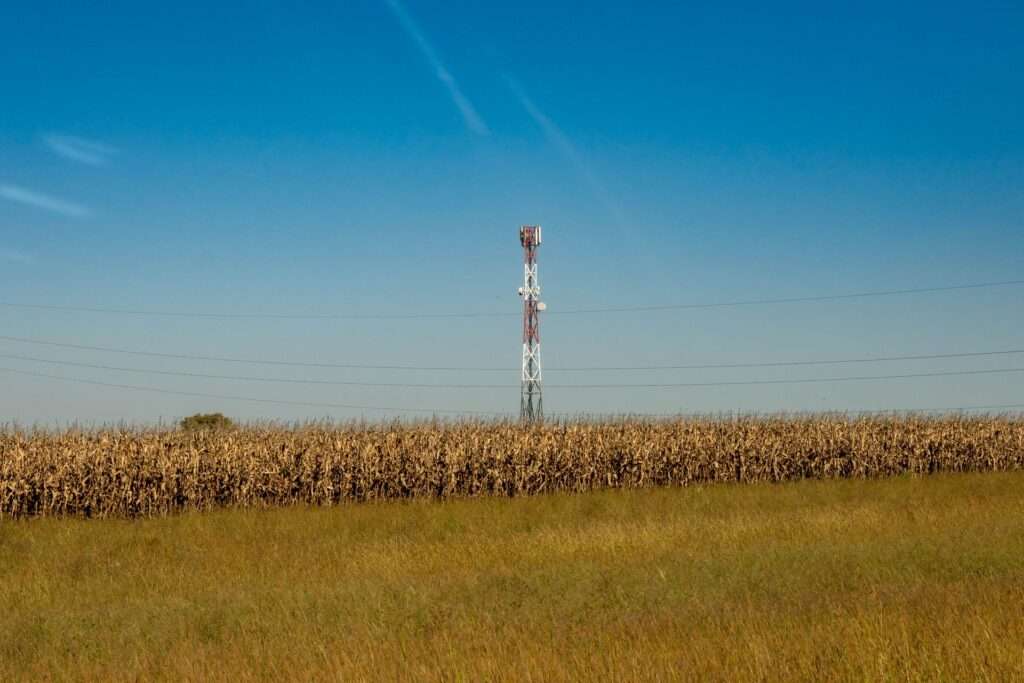 A Turning Point for the Digital Divide: Cytranet CTO Doug Roberts on Why Reliable Internet Is Finally Within Everyone's Reach 11 Communication tower standing in a rural field under a clear blue sky, representing expanding broadband connectivity