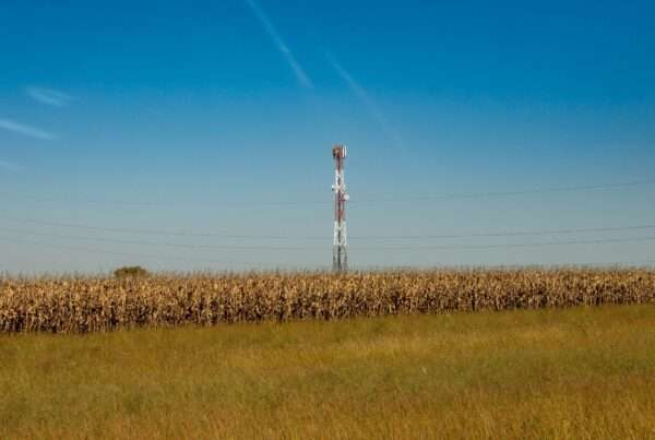 A Turning Point for the Digital Divide: Cytranet CTO Doug Roberts on Why Reliable Internet Is Finally Within Everyone's Reach 4 Communication tower standing in a rural field under a clear blue sky, representing expanding broadband connectivity