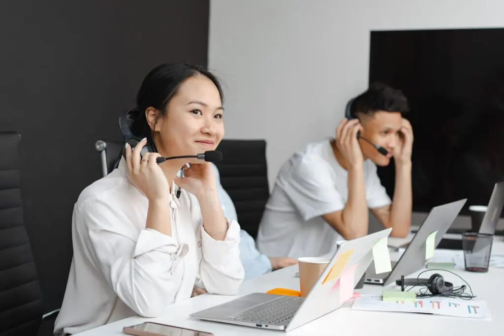 Diverse team of call center agents wearing headsets and working at laptops in a modern office, representing agentic voice AI and cloud call handling