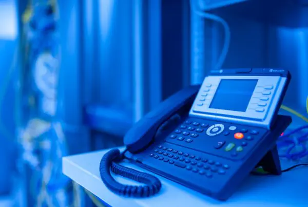Close-up of a modern VoIP desk phone in an office, representing a cloud-based business phone system