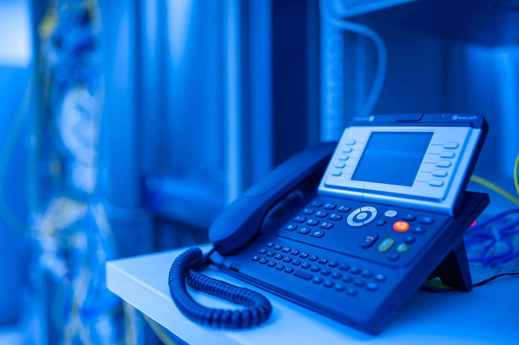 Close-up of a modern VoIP desk phone in an office, representing a cloud-based business phone system