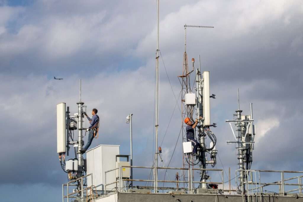 Two telecom technicians working on a communications tower, representing the skilled jobs behind Cytranet's fiber and wireless network infrastructure across Nevada, Arizona, and California