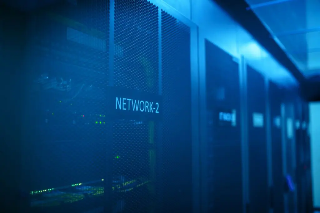 Rows of illuminated network servers in a modern data center, representing the IT infrastructure municipalities and businesses must secure against cyberattacks