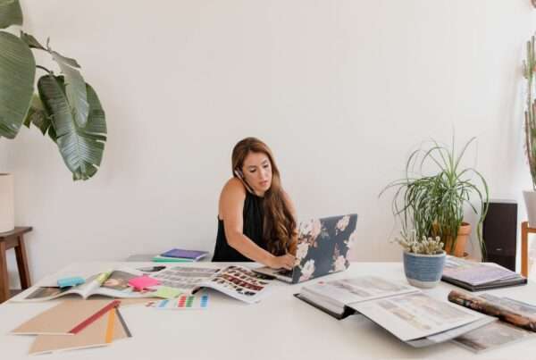 Small business owner working at a desk with a phone and laptop