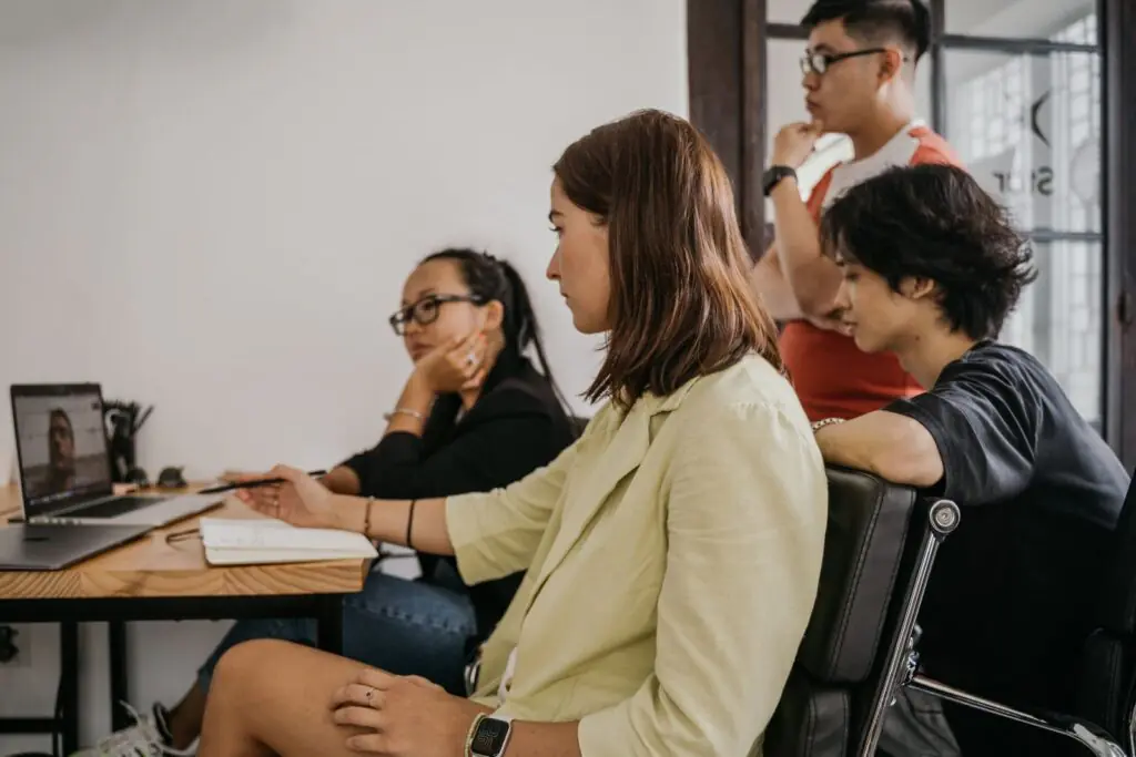 Four colleagues in a modern office collaborating on a video conference call using business communication apps