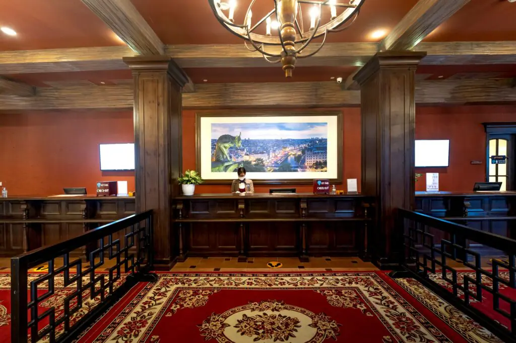 Hotel receptionist working at the front desk of a modern hotel lobby