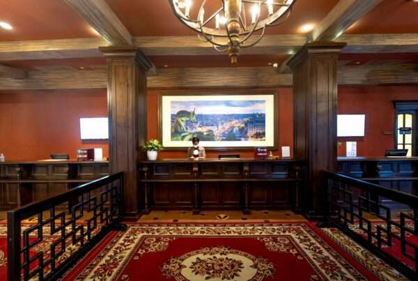 Hotel receptionist working at the front desk of a modern hotel lobby