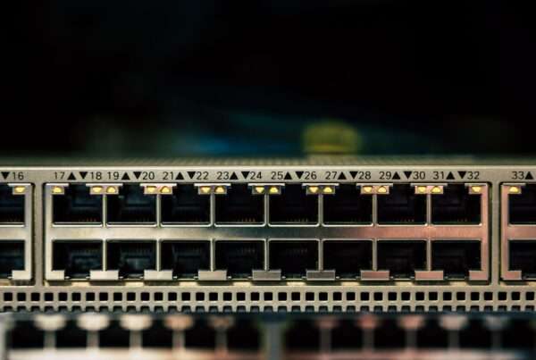 Close-up of a business network router and ethernet cables, representing the move from IPv4 to IPv6 addressing in company networks