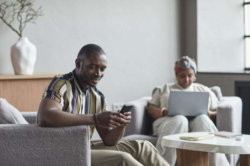 Business travelers using laptops on high-density managed Wi-Fi in a modern hotel lobby