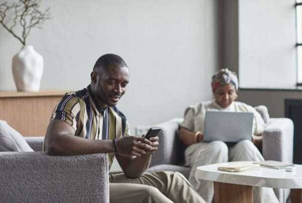 Business travelers using laptops on high-density managed Wi-Fi in a modern hotel lobby