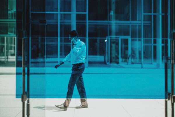 Business professional walking outdoors while taking a call on a smartphone
