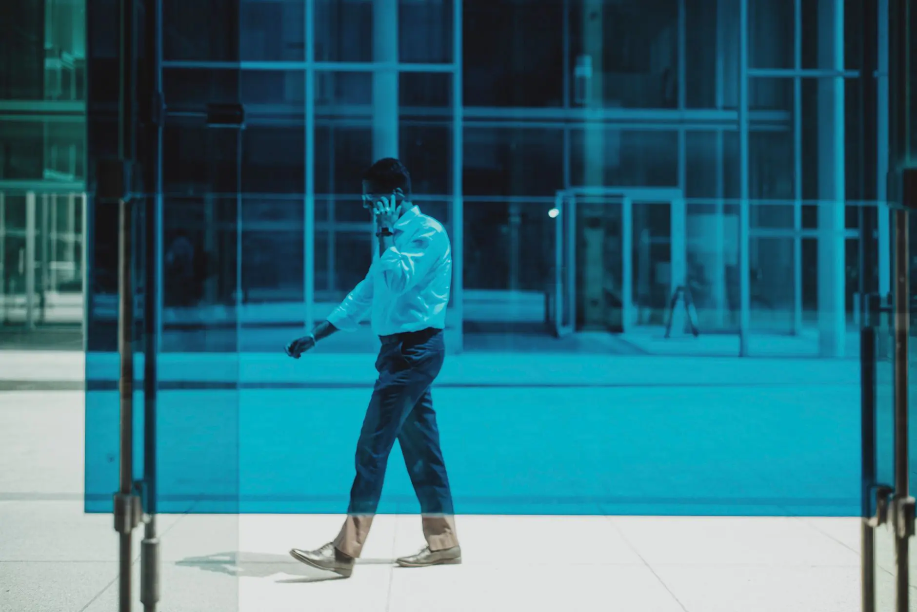 Business professional walking outdoors while taking a call on a smartphone
