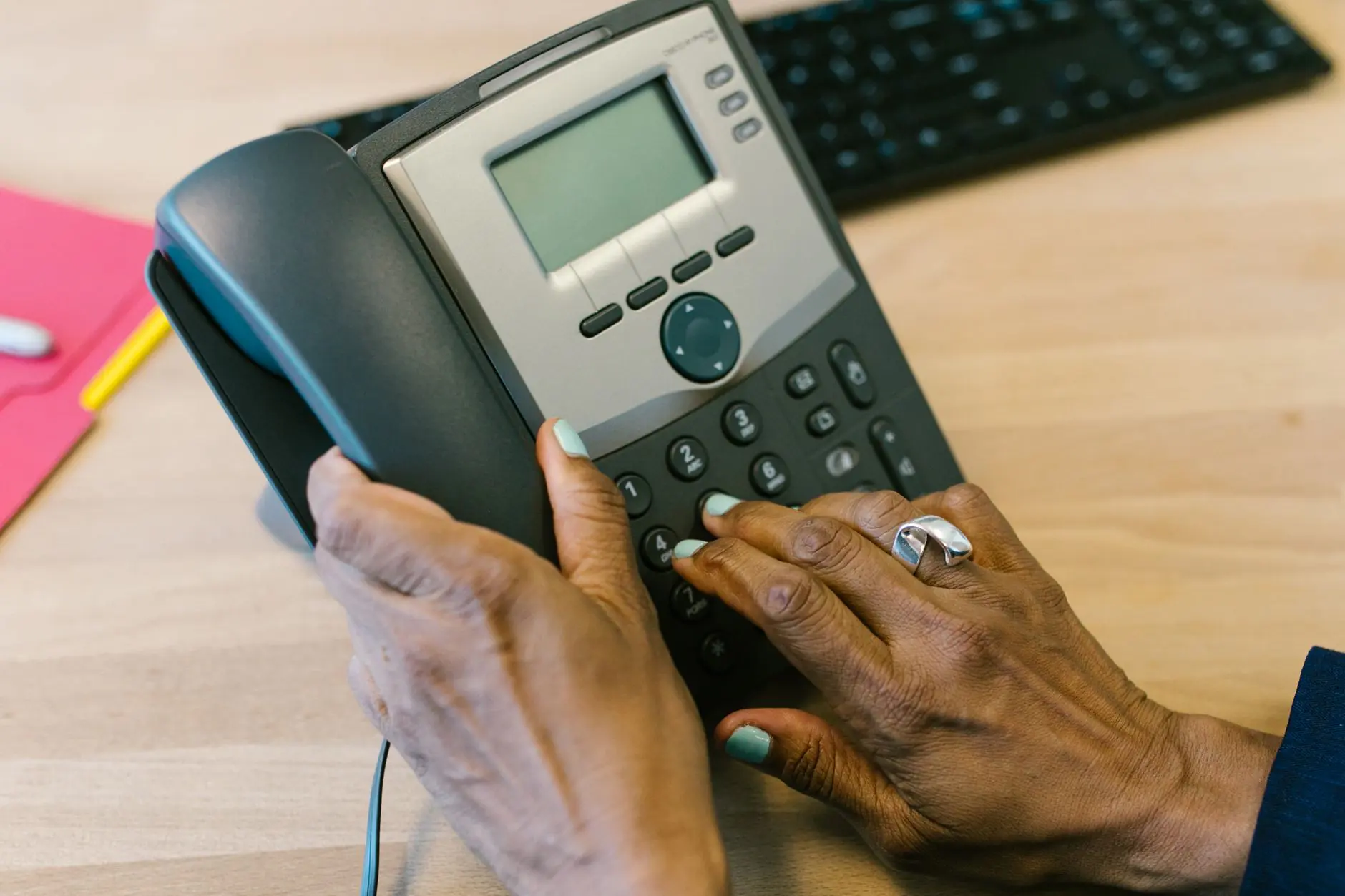 Business desk phone on an office desk representing the choice between PBX and VoIP phone systems