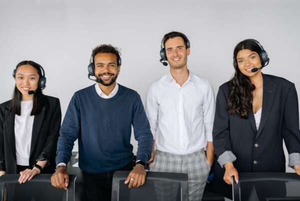Customer support agents working at desks with headsets and monitors
