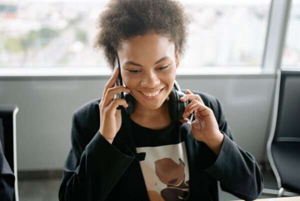 Auto Dialer Software: A Practical Guide for Outbound Teams 4 Smiling sales representative wearing a headset while speaking on the phone in an office