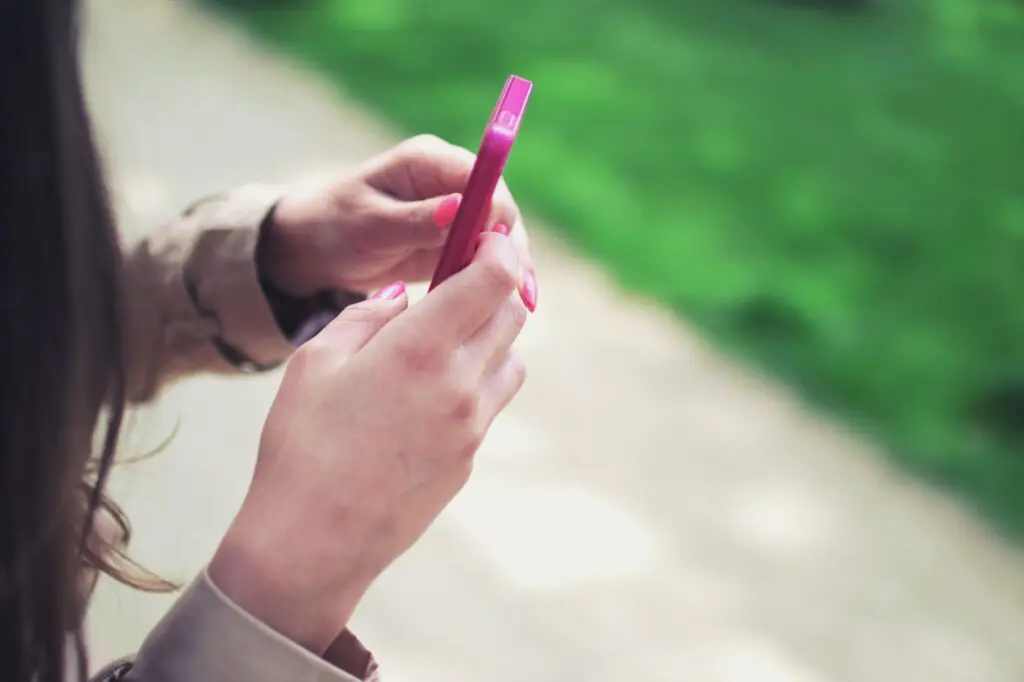 Person using a smartphone for social media customer conversations connected to a business CRM