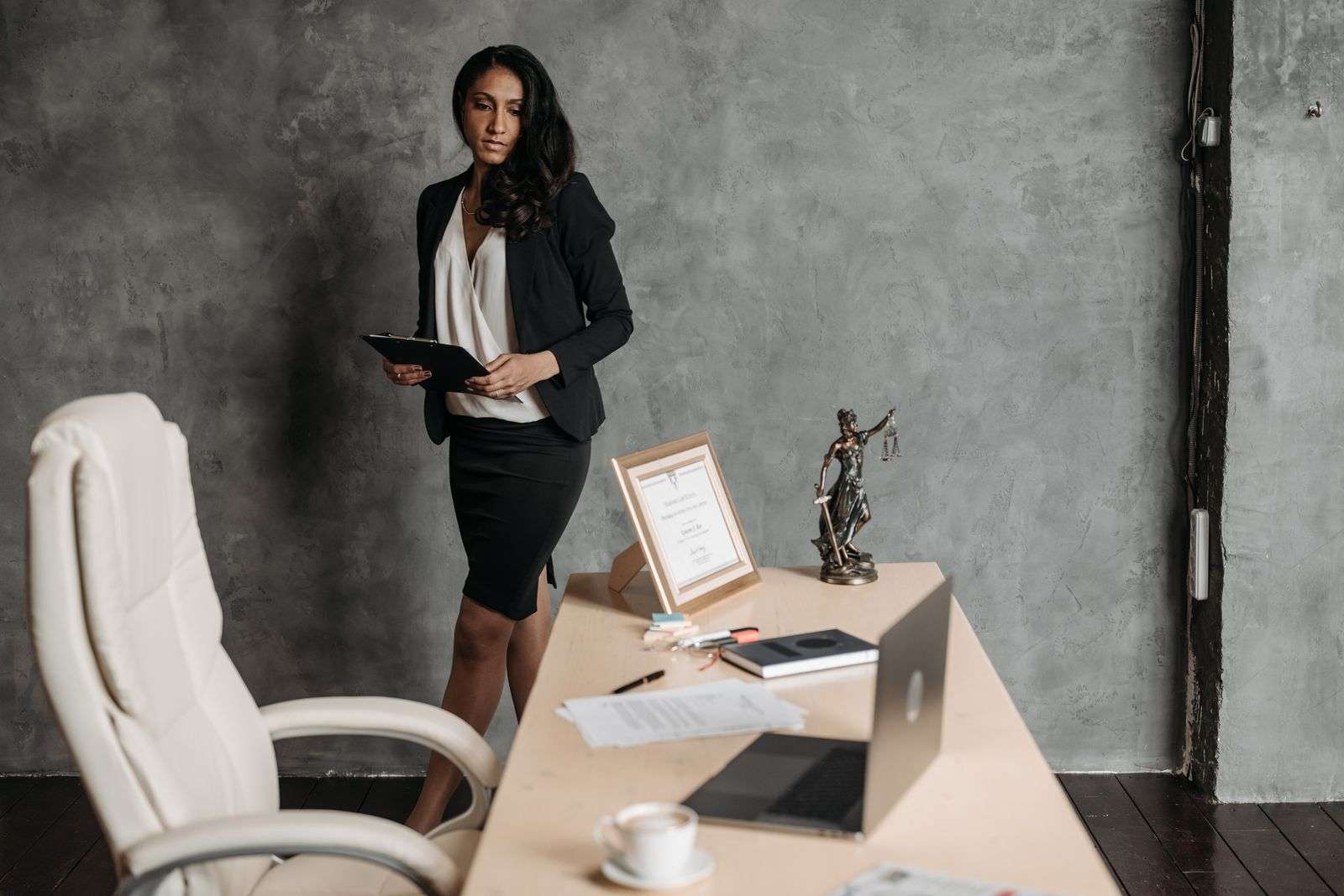 AI Compliance Risks in Business Communications: What Every Organization Should Watch For 1 Professional reviewing documents in an office with a scales of justice statue on the desk