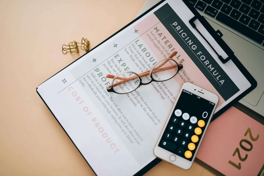 Business pricing analysis documents and phone on a desk representing AI phone agent pricing models