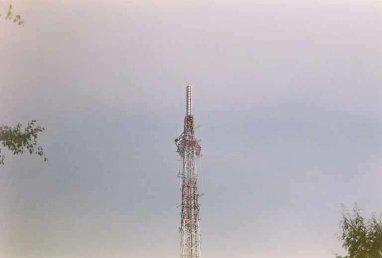 Tall broadcast radio tower against a cloudy sky representing mission-critical internet and fiber connectivity for the broadcast industry