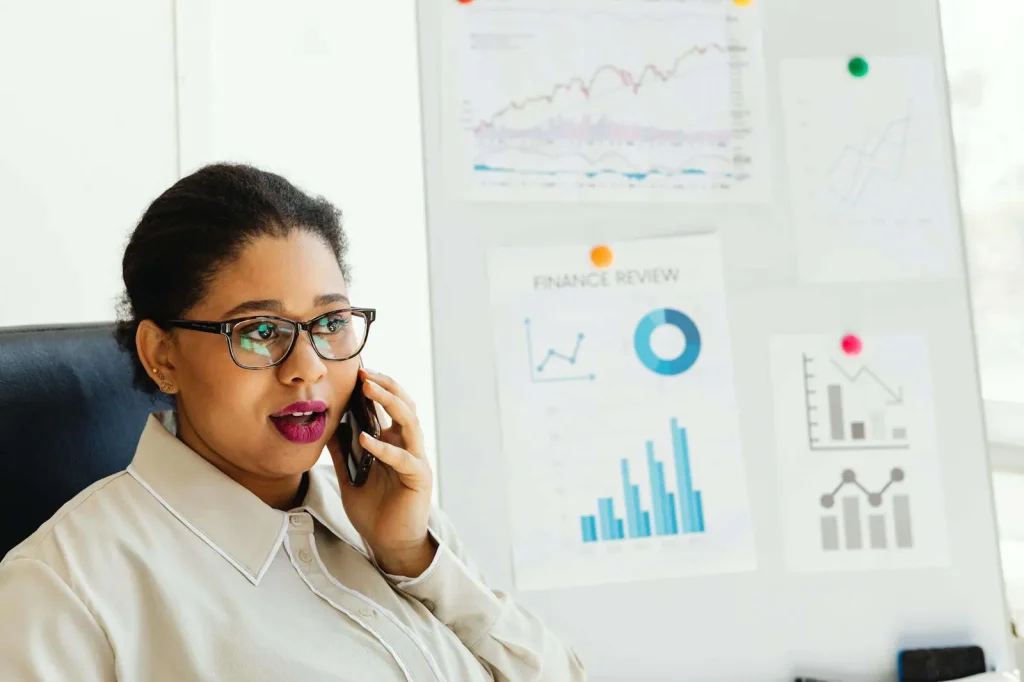 Businesswoman on a phone call analyzing financial and call data on charts